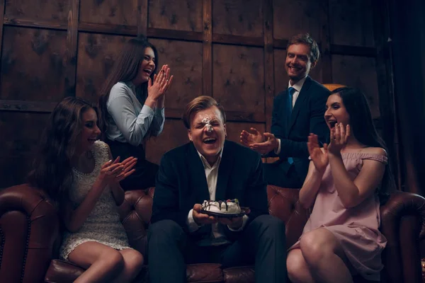 Bonito rosto de homem coberto de bolo de aniversário — Fotografia de Stock