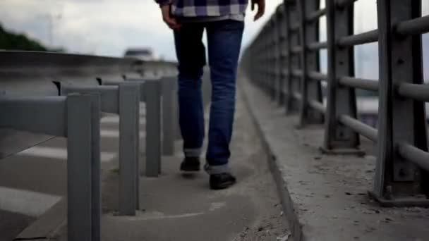 Ung man promenader längs bron — Stockvideo