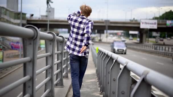 Young man walking along bridge — Stock Video
