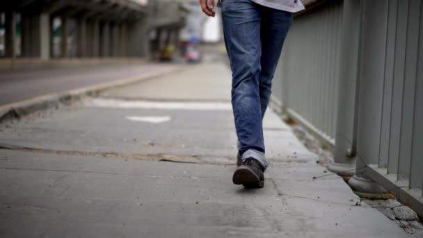 Ung man promenader längs bron — Stockvideo