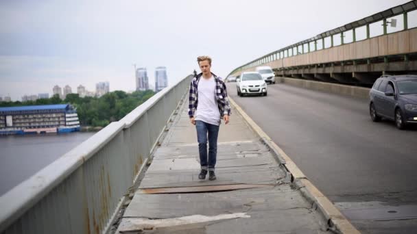 Joven caminando por el puente — Vídeo de stock