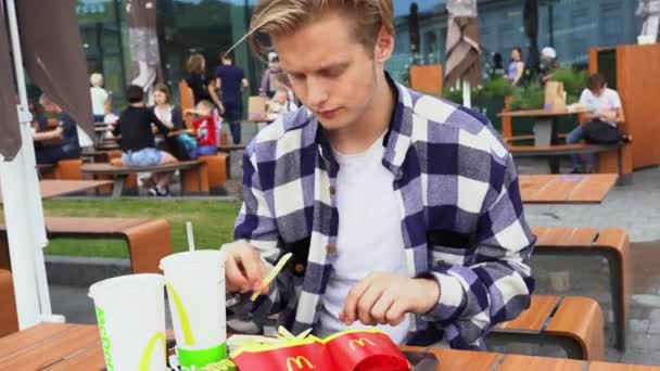 Handsome man having fast food in Mc Donalds — Stock Video