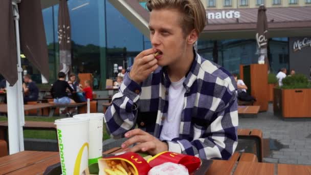 Handsome man having fast food in Mc Donalds — Stock Video