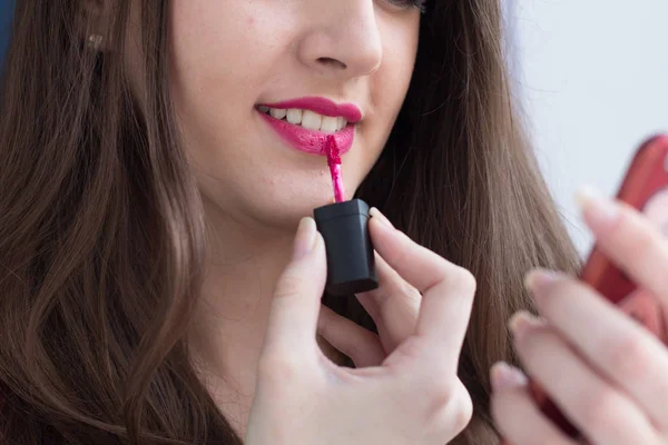 Hermosa chica aplicar lápiz labial. — Stockfoto