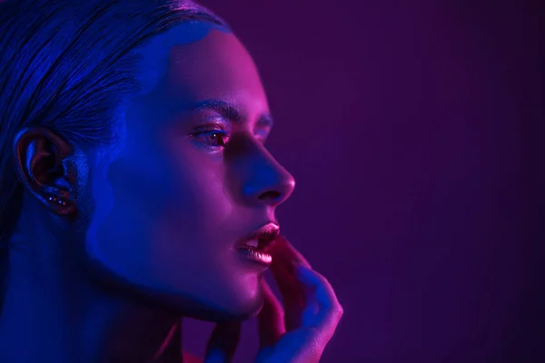 Sexy Model in fotostudio op paars met blauwe Neon-verlichting — Stockfoto