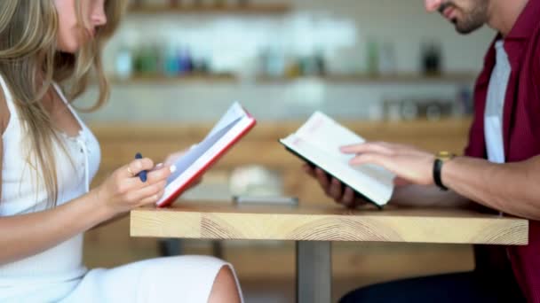 Jeune couple lisant des livres à une date — Video