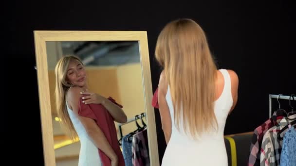 Mujer bonita intenta un nuevo vestido en el vestidor . — Vídeos de Stock