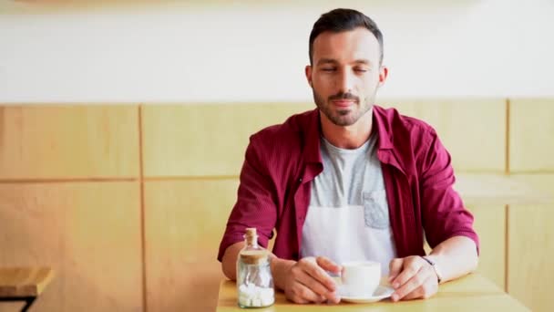 Guapo barbudo tomando un café en el café — Vídeo de stock