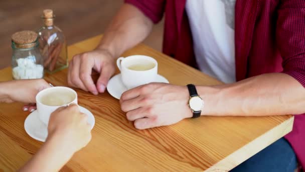 Jong koppel in liefde zitten in een cafe en met koffie — Stockvideo