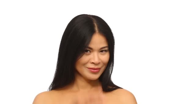 Hermosa morena oriental mujer sonriendo tocando el pelo . — Vídeo de stock