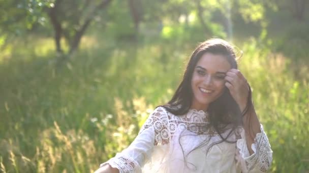 Brünette mit einem attraktiven Lächeln im romantischen Stil spaziert im Garten. — Stockvideo