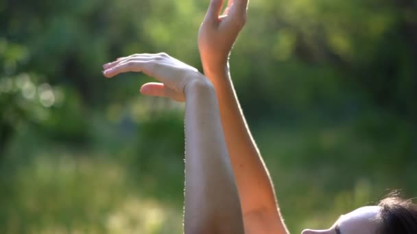 Jemné pohyby rukou mladé dívky na pozadí přírody. — Stock video