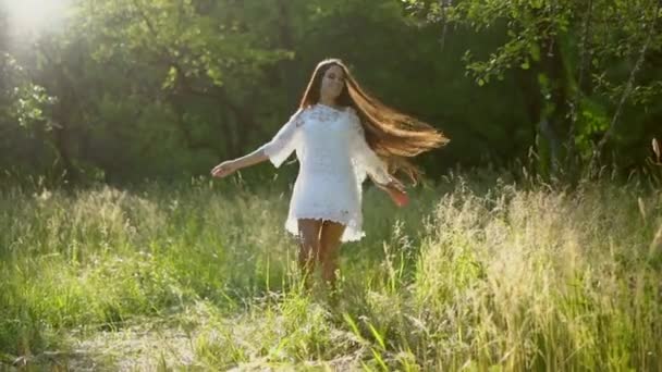 Милая девушка с длинными волосами гуляет по саду . — стоковое видео