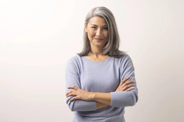 Beautiful grey-haired woman with crossed arms — Stock Photo, Image