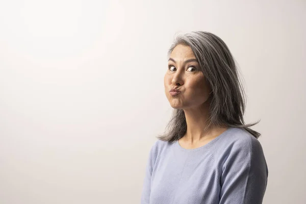 Beautiful mature woman is making funny faces — Stock Photo, Image