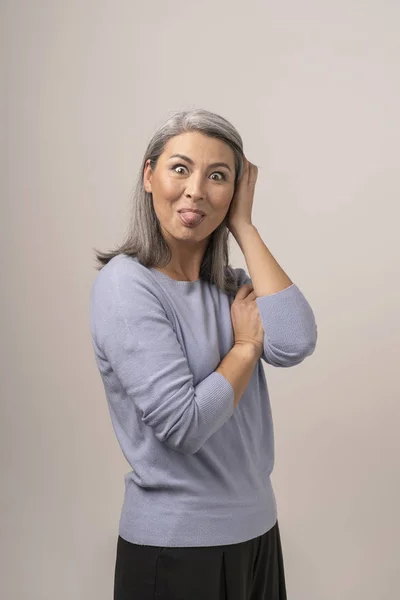 Asiatische reife Frau zeigt Zunge. Porträt — Stockfoto