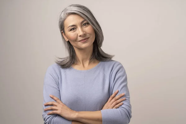 Mooie Mongoolse vrouw met grijze haren op een witte achtergrond. — Stockfoto