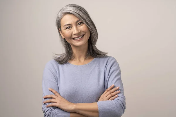 Lächelnde asiatische Seniorin mit verschränkten Armen — Stockfoto