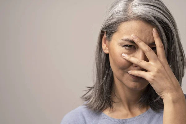 Schöne Frau guckt durch ihre Finger — Stockfoto