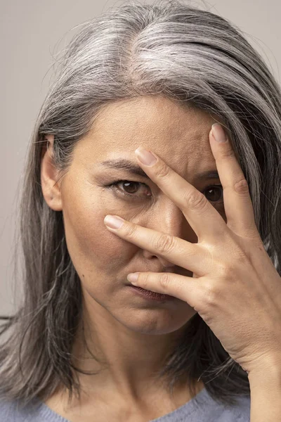 Beautiful woman is peeping through her fingers — Stock Photo, Image