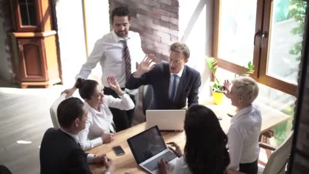 Uma equipe jovem de parceiros de negócios está se preparando para um encontro importante em uma sala de reuniões ensolarada . — Vídeo de Stock