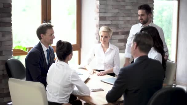 Een jong Team van zakenpartners zijn voorbereiding voor een belangrijke vergadering in een zonnige vergaderruimte. — Stockvideo