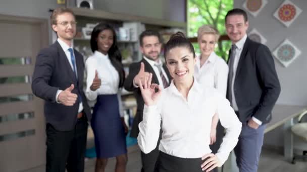 Mujer de negocios confiada de pie frente a su exitoso equipo — Vídeo de stock