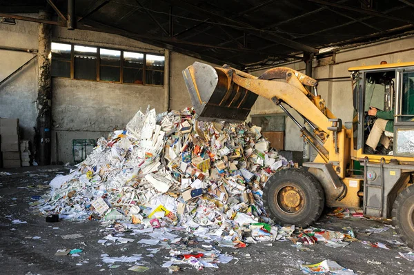 Escavadeira despeja lixo de papelão em usina de reciclagem de resíduos — Fotografia de Stock