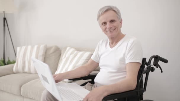 Людина з обмеженими можливостями у інвалідному кріслі, використовуючи ноутбук у лікарні — стокове відео