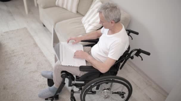 Tekerlekli sandalyede oturan bir dizüstü bilgisayar onun Ward gri saçlı adam. — Stok video
