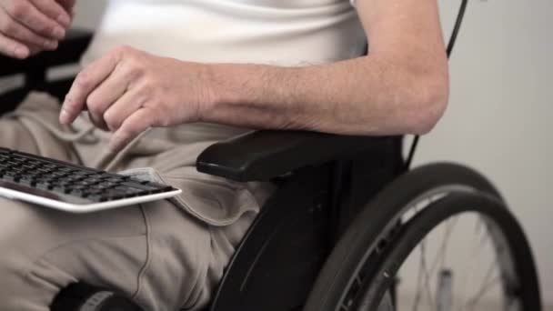 Homme handicapé sur un fauteuil roulant tapant sur l'ordinateur portable — Video