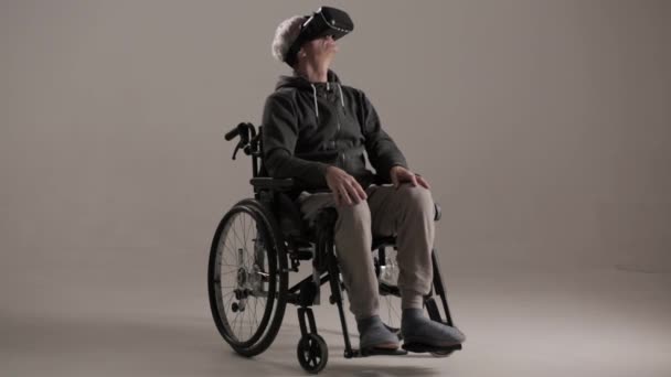 Tekerlekli sandalyede bir yetişkin sanal gerçeklik gözlük koymak. — Stok video