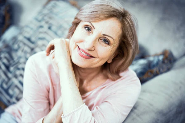 Retrato de una mujer mayor de 50 años que está descansando en casa en la sala de estar . — Foto de Stock