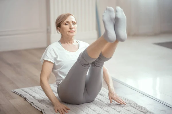 European Looking Woman Over 50 Years Old Doing Yoga at Home in the Living Room.