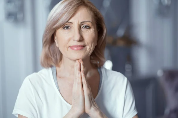 A la hermosa mujer de más de 50 años le gusta hacer yoga en casa . —  Fotos de Stock