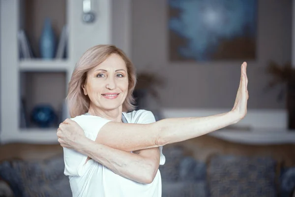 Жінка середнього віку робить йогу вдома — стокове фото