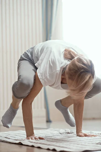 Vrolijke volwassen vrouw maken van yoga-oefeningen — Stockfoto