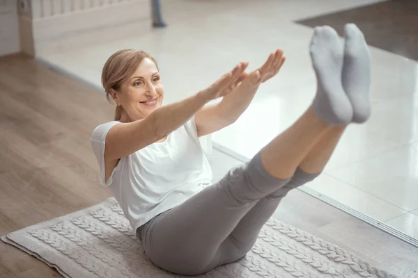 Mujer madura alegre haciendo ejercicios de yoga — Foto de Stock