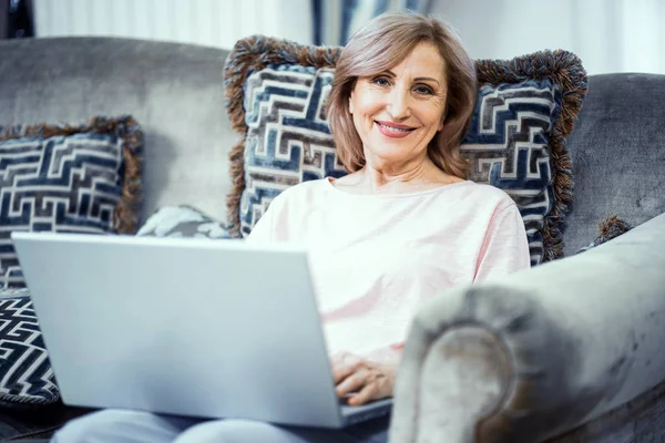 Femme heureuse utilisant un ordinateur portable à la maison — Photo