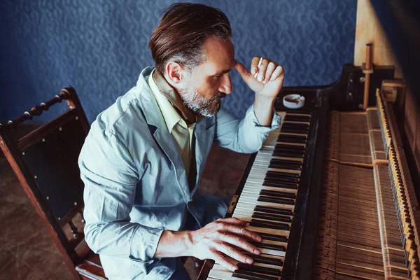 Bonito músico compõe música sentada ao piano — Fotografia de Stock
