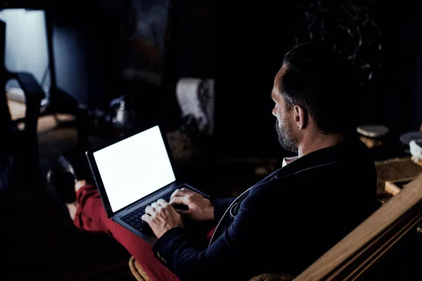 O homem atraente está sentado em um laptop no escuro. Freelance — Fotografia de Stock