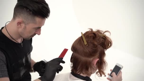 Peluquero sosteniendo un peine y tijera perfumando un corte de pelo para un cliente de jengibre — Vídeo de stock