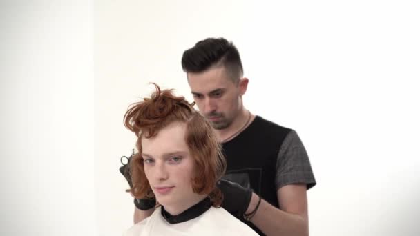 Master Hairdresser Doing Haircut to a Young Guy with Red Long Hair. — Stock Video