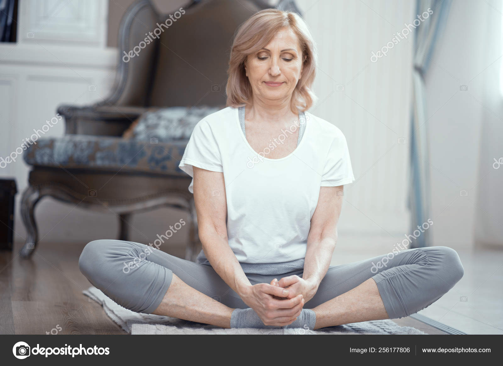 Pregnant sportswoman sitting with crossed legs in yoga pose on fitness mat  at home Stock Photo - Alamy