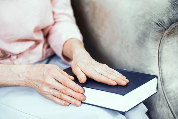 Female hands are laying on a blue book. — Stock Photo, Image