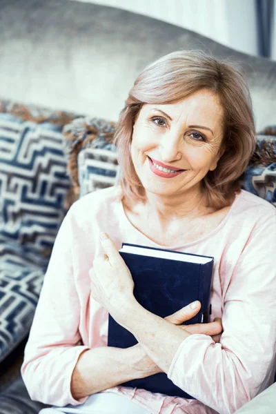 Mulher madura bonita está lendo um livro — Fotografia de Stock