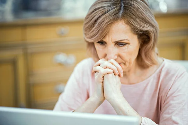 Mulher concentrada olha penosamente no laptop — Fotografia de Stock