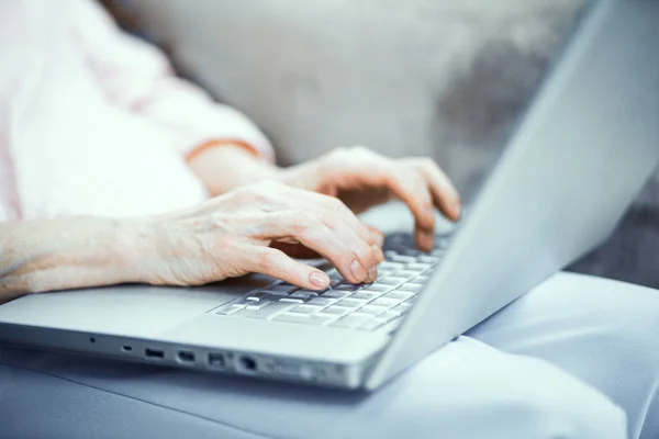 Mains de femme mature tapant sur ordinateur portable — Photo