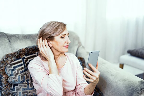 Beautiful mature woman takes selfie at home — Stock Photo, Image