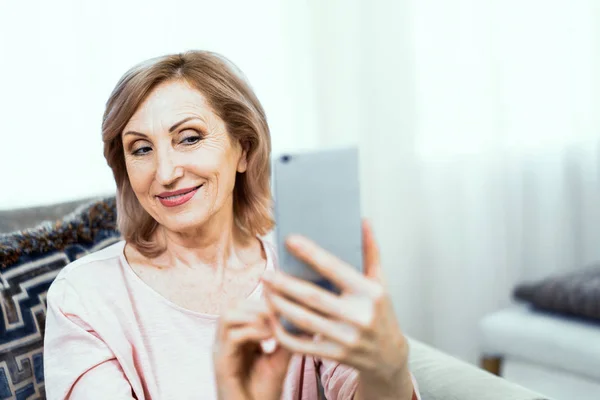 Mulher madura bonita leva selfie em casa — Fotografia de Stock